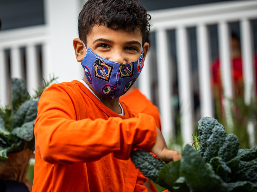 Student gardening in UrbanPromise’s after school program